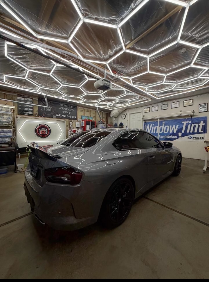 Gray BMW M240i with full ceramic window tint under the studio hex lighting at Rosie's Window Tint