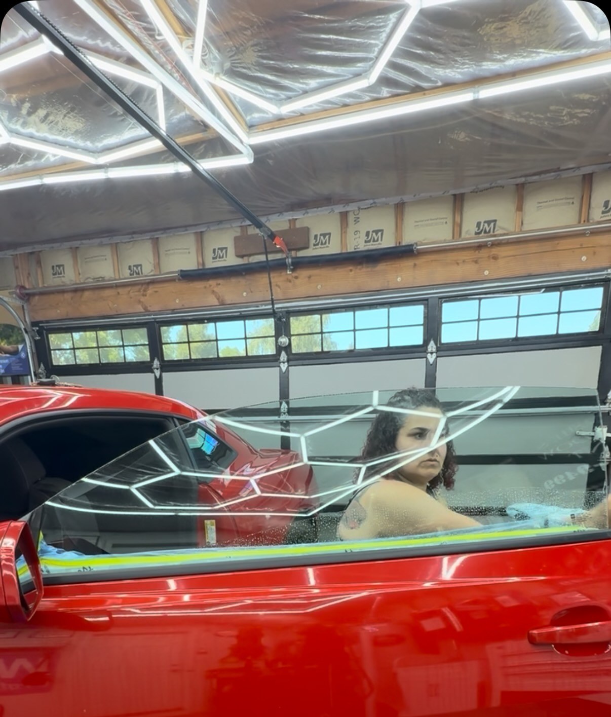 Ceramic tint being installed on a red Chevy Camaro inside Rosie's studio