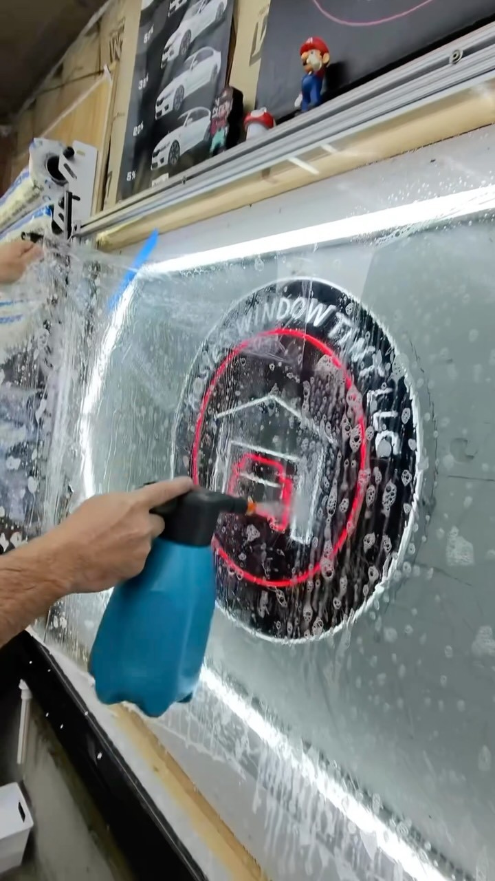 Film being prepped against the Rosie's Window Tint logo backdrop